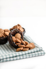 Small cracker cookies in a basket on a linen napkin on a white background