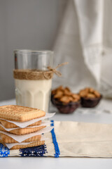 Cookies and a glass of milk close up on a linen napkin on a white background