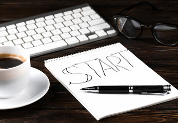Blank notepad over laptop and coffee cup on office wooden table