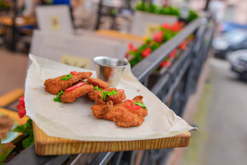 Mixed deep fried appetizer with dip sauce. Fried chicken, beer snack with dip sauce served on a wooden board.