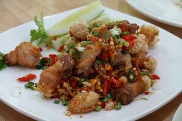 Stir fried pork belly slice with chilli and salt on a white plate. It is delicious and slightly spicy. Thaifood
