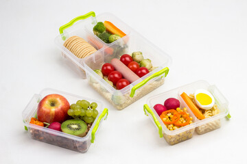 School lunch boxes boxes with fruits, nuts and vegetables on table