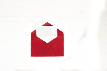 red envelope on a white background with thuja branches. the top view 