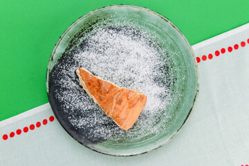 Fresh cheesecake, Ukrainian cuisine concept. Piece of cheese cake served on a plate over bright green background.