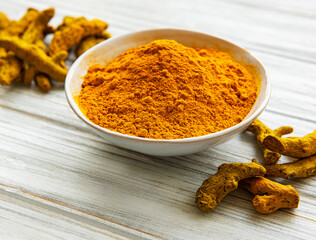 Bowl with turmeric powder and roots