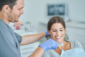 Fototapeta premium Male dentist and woman in dentist office