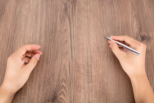 Holding Pen Pretending To Write Something On The Table