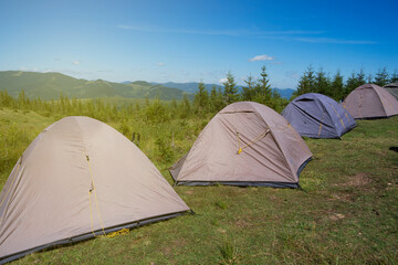 Camping with tents in high mountains on background
