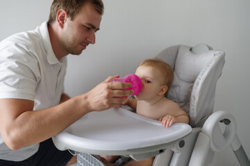 Father helping daughter drink water - Powered by Adobe