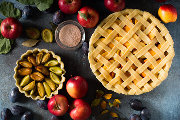Autumn and summer pie with apple and plum on dark  background