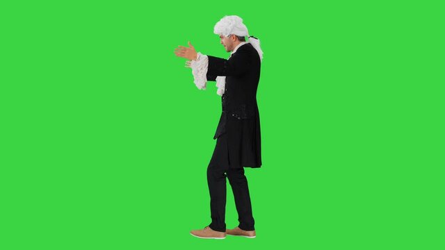 Man dressed like Wolfgang Amadeus Mozart conducting an orchestra on a Green Screen, Chroma Key.