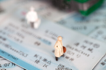 Miniature doll model standing on the train ticket