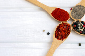 Spice mix in a wooden spoon on a white wooden background. Flatlay.