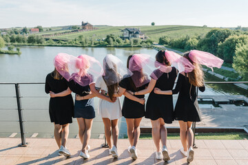 Bride and bridesmaids stands back on a beach and celebrating bachelorette party. Beautiful sexy...