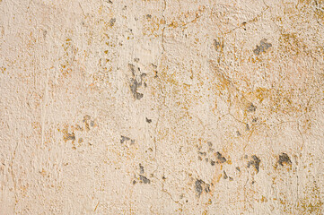 Grunge background of cracked cloud peeled putty wall in beige tones