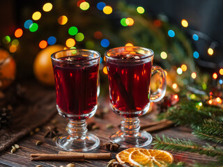 mulled wine in glasses on a wooden background with spices and ingredients with Christmas decor