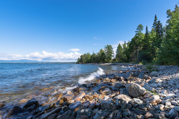 A foamy wave rolls over the rocky shore of Lake Baikal. Buryatia, Russia
