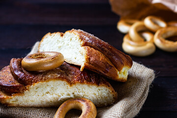 A bun, a bagel on a dark wooden background. Bakery counter