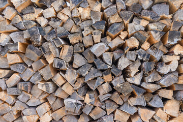 A chopped firewood stack for the background. The heating a rural house wood burning stove. Heating season.    Forest sawing. Environmental protection. Ecology. Place for text