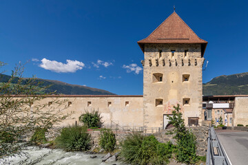 Fototapeta premium The Porta Tubre tower and the Adige River in Glorenza, South Tyrol, Italy, on a sunny day