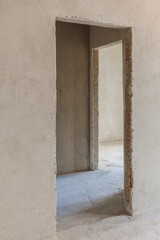 Doorway in the plastered wall inside the new building. Doorway without door