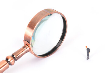 A magnifying glass and a character model in formal wear on a white background
