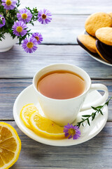 White cup of tea with lemon, bun, bagel and cookies. Lunch break at a coffee shop