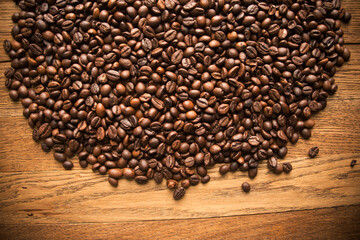 Fresh coffee beans on wood and linen bag, ready to brew delicious coffee