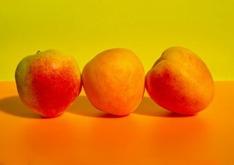 Apricots on colorful background. Minimal raw food concept. Simple modern fruits with hard light and shadow.