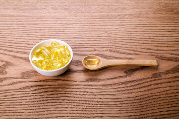 Fish oil pills on the wooden table.