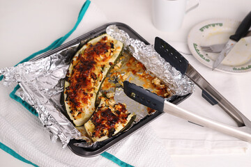 baked zucchini with chicken meat on a white plate. Eaten food.