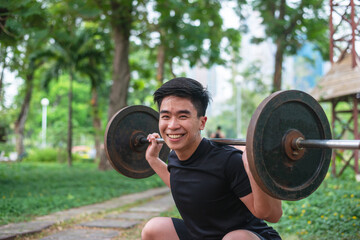 young man do  barbell squat smile on camera