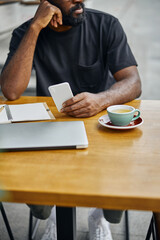 Young man with modern gadgets at the table in cafe