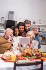 Selective focus of multiethnic family having video call on digital tablet during thanksgiving celebration
