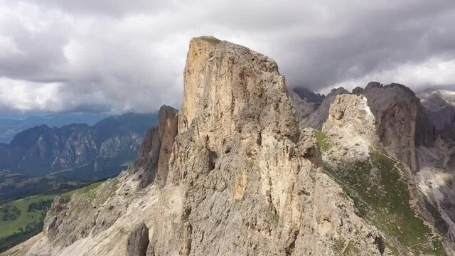 Rotating drone shot flying around jagged peak in the spectacular Dolomites mountain ranges, panoramic natural landscape in Italy Europe

