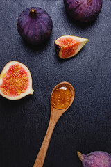 Fig jam in a wooden spoon and fresh figs