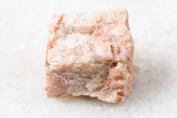 closeup of sample of natural mineral from geological collection - rough Feldspar rock on white...