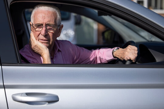 Worried Senior Male Driver Looking Out Of Car Window