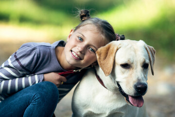 Portrait of little girl with a dog outdoors.