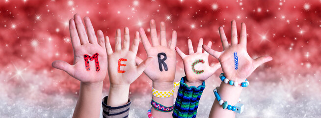 Children Hands Building Colorful French Word Merci Means Thank You. Red Snowy Christmas Winter Background With Snowflakes And Sparkling Lights