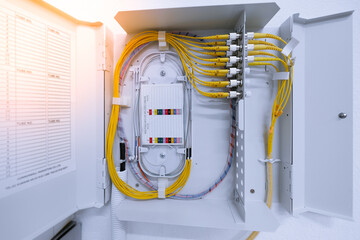 fiber optic cable connected to enclosure box in a technology data center room. Selective focus