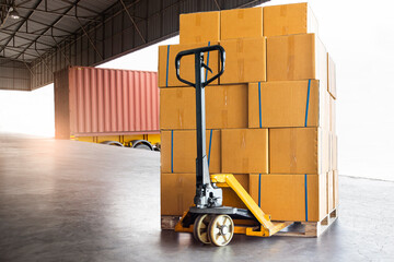 Logistics and Transportation. Shipment goods, Cargo freight truck, Delivery. Hand pallet jack with stack cardboard boxes on pallet waiting to load into cargo container.
