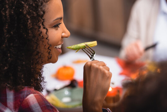 Selective Focus Of African American Woman Eating Asparagus During Thanksgiving Dinner