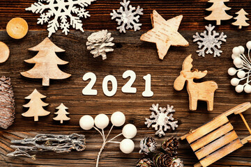 Letters Building The Word 2021. Wooden Christmas Decoration Like Tree, Sled And Star. Brown Wooden Background