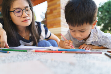 Asian boy drawing and painting with his mother