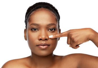 beauty and people concept - portrait of young african american woman with bare shoulders pointing to her nose over white background