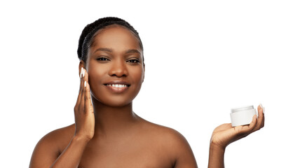 beauty and people concept - portrait of happy smiling young african american woman with bare shoulders applying moisturizer to her face over white background