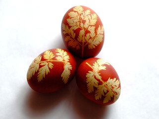 Painted Easter eggs on a white background. Floral pattern on a red eggshell. Festive food.