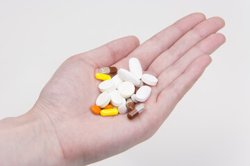 multicolored pills lie in hand