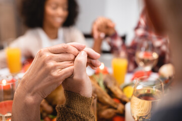 selective focus of senior man and woman holding hands on thanksgiving